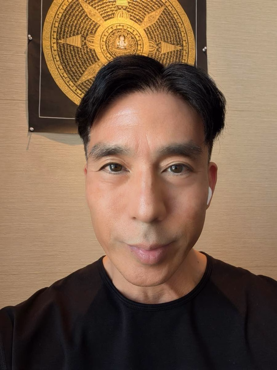 Portrait of author Alex Yamane in front of a golden Buddhist mandala thangka