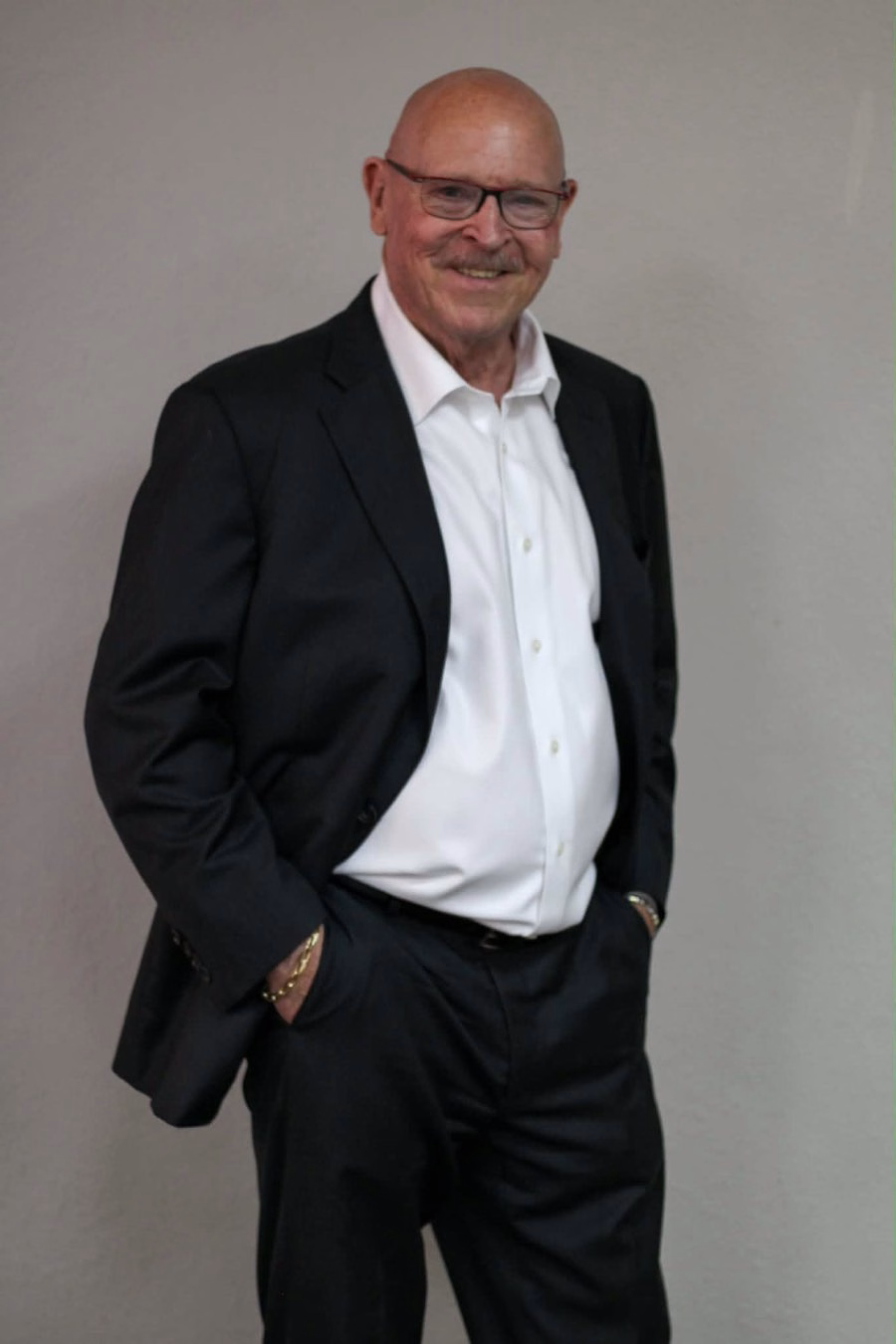 Frank Cheesman, author of Life at 200 Miles an Hour, smiling in a dark suit and white shirt