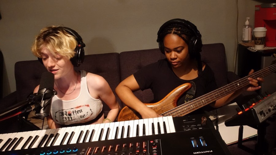 Jeán et Joie members playing keyboard and bass guitar in a home studio